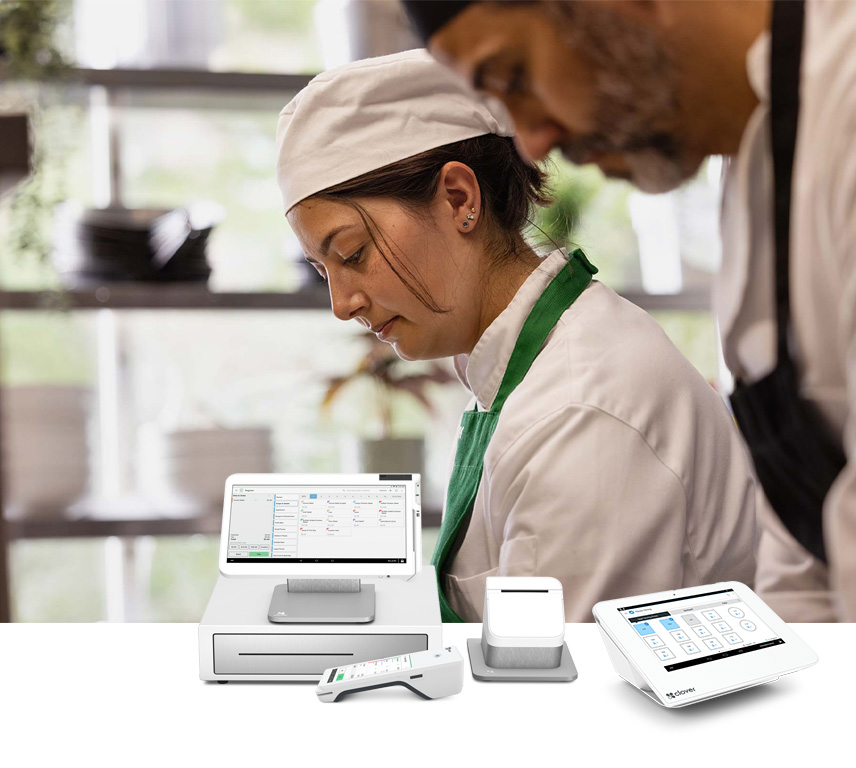 Chef in a green apron with Clover POS systems in the foreground